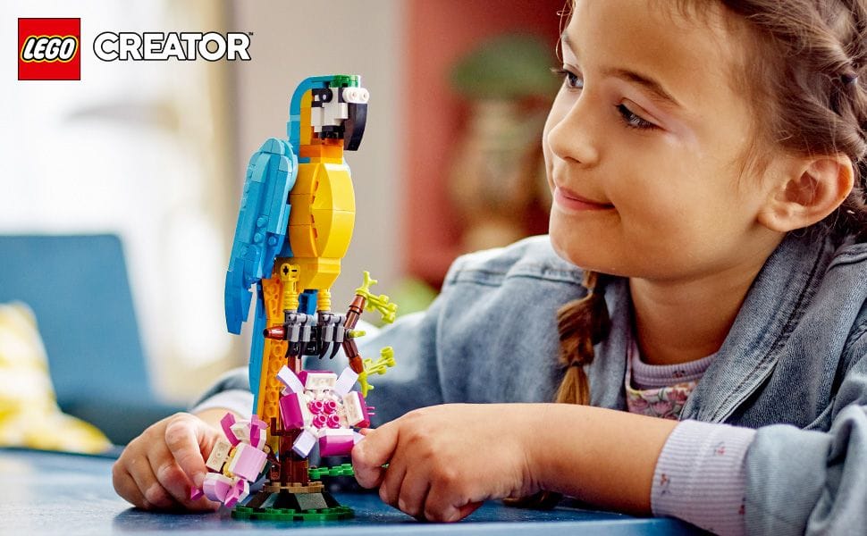 Photo of a girl and a buildable blue and yellow LEGO parrot